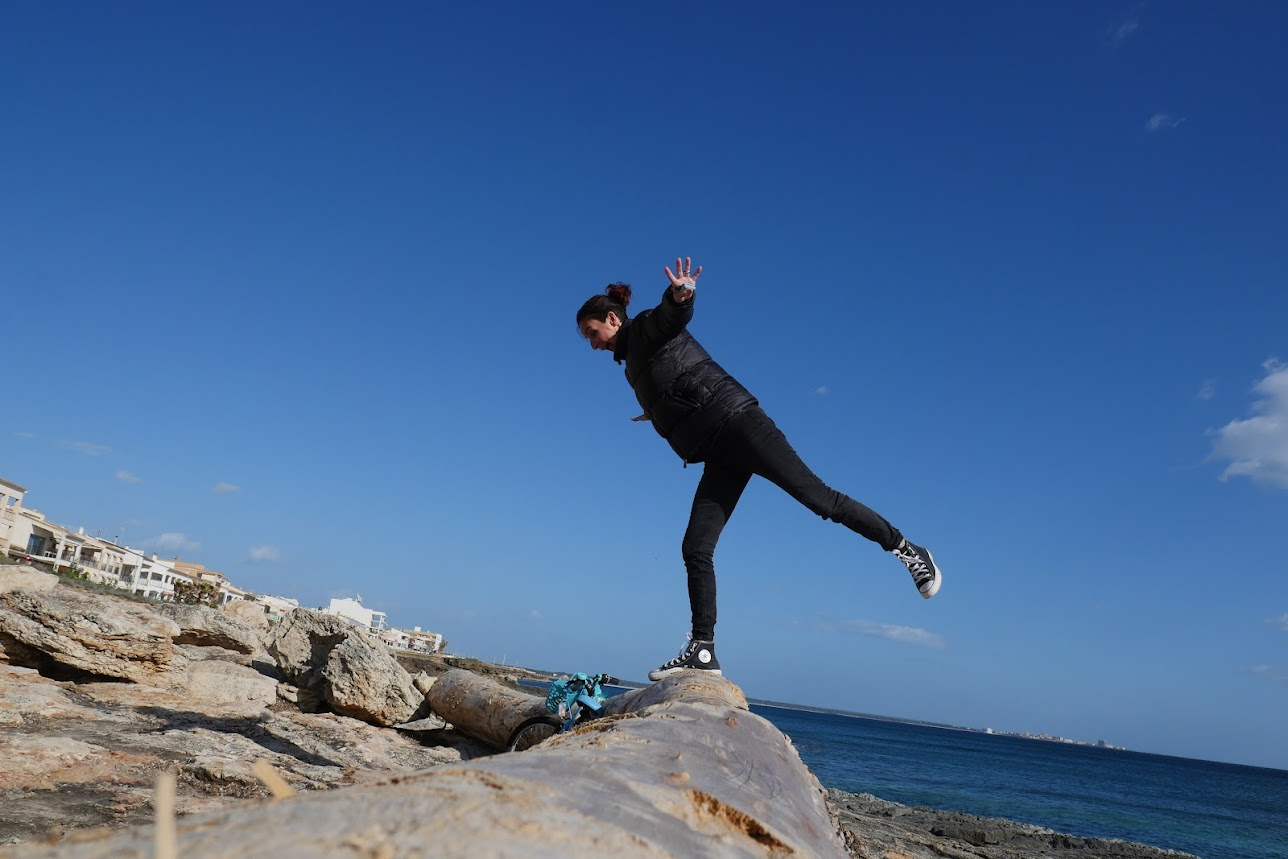 Amely en équilibre sur les rochers face à la mer à Majorque